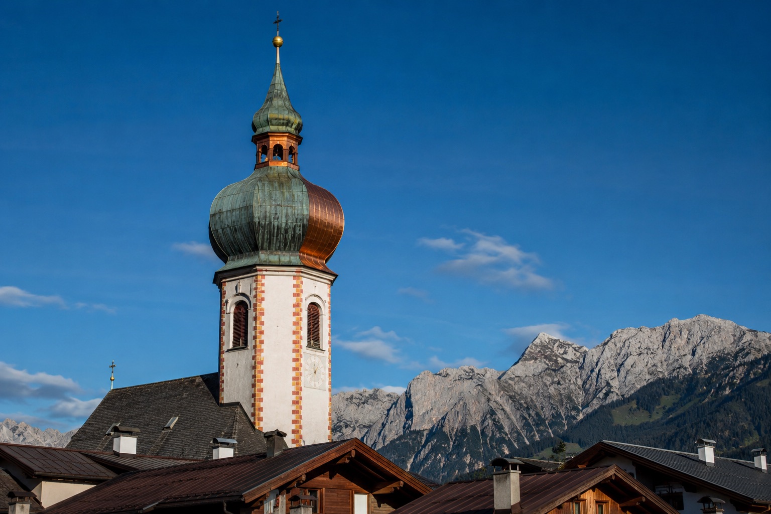 Kirchturm mit Kupfer-Zwiebelhaube und Patina in Tirol